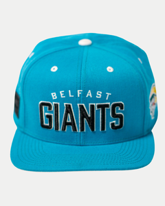 The Belfast Giants Teal Snapback Cap features "Belfast Giants" embroidered in black and white on the front, white eyelets, side team crest patches, and is shown against a white background.