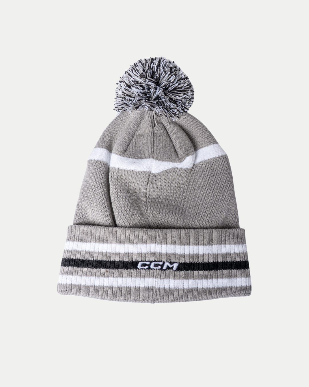 The 25-26 CCM Grey Pom Beanie from Belfast Giants Store by National Merchandise features gray knit, white and black stripes, a folded brim with the CCM logo, and a black-and-white pom-pom, pictured on a plain white background.