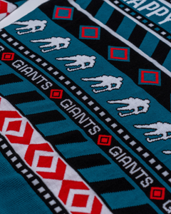 Closeup of a Belfast Giants Christmas Jumper by Belfast Giants Store, featuring knit patterns of running white lions, red and white diamonds, and bold "GIANTS" text—perfect festive wear for fans this holiday season.