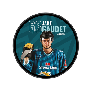 A hockey player in blue gear holds a stick facing forward. Text reads 63 Jake Gaudet 2025/26 and the Stena Line logo on a Belfast Giants jersey. Teal background with circular black border. Product: Belfast Giants 2025-26 Player Puck.