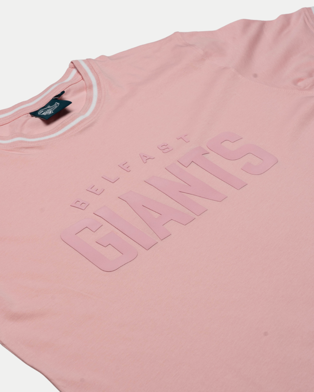 The Kids Belfast Giants T-shirt Pink by Belfast Giants features bold "BELFAST GIANTS" lettering, a black collar tag, and crisp white neck trim—delivering standout supporter style.