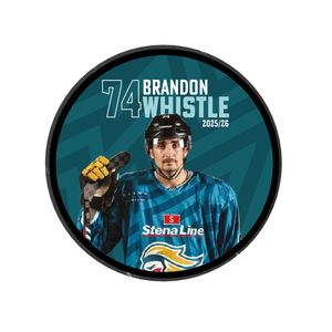 The 2025-26 Player Puck by Belfast Giants showcases Brandon Whistle (#74) in a blue “Stena Line” jersey with bird logo, holding a stick. “74 Brandon Whistle 2025/26” is printed on a teal background. Limited edition.