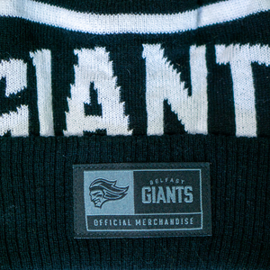 A close-up of the Belfast Giants Beanie Black and White by Belfast Giants, featuring GIANTS in white letters and a label with the team’s official giant head logo.