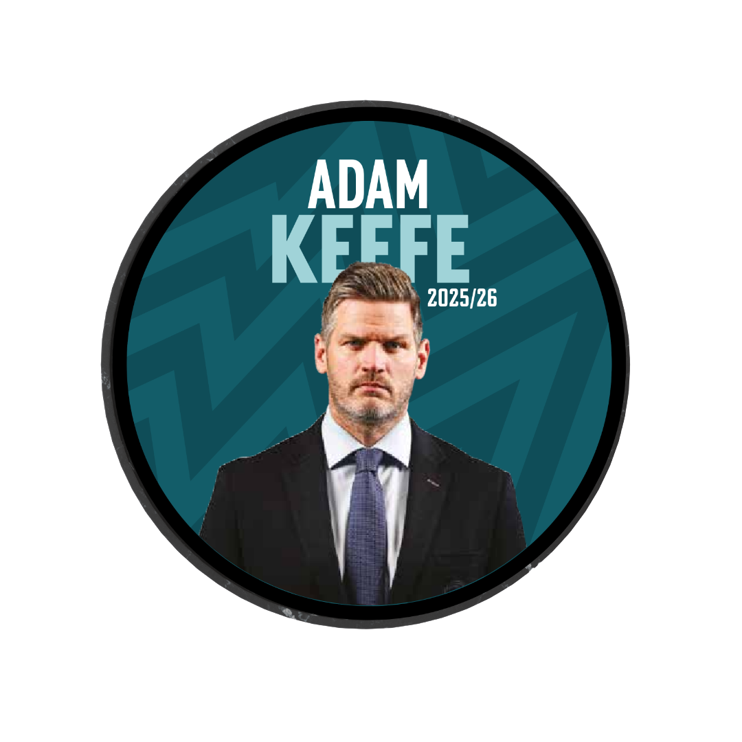 A circular graphic features a serious man in a suit on a teal zigzag background. Bold text reads 2025-26 Player Puck—an ideal limited edition collectible for Belfast Giants ice hockey fans.