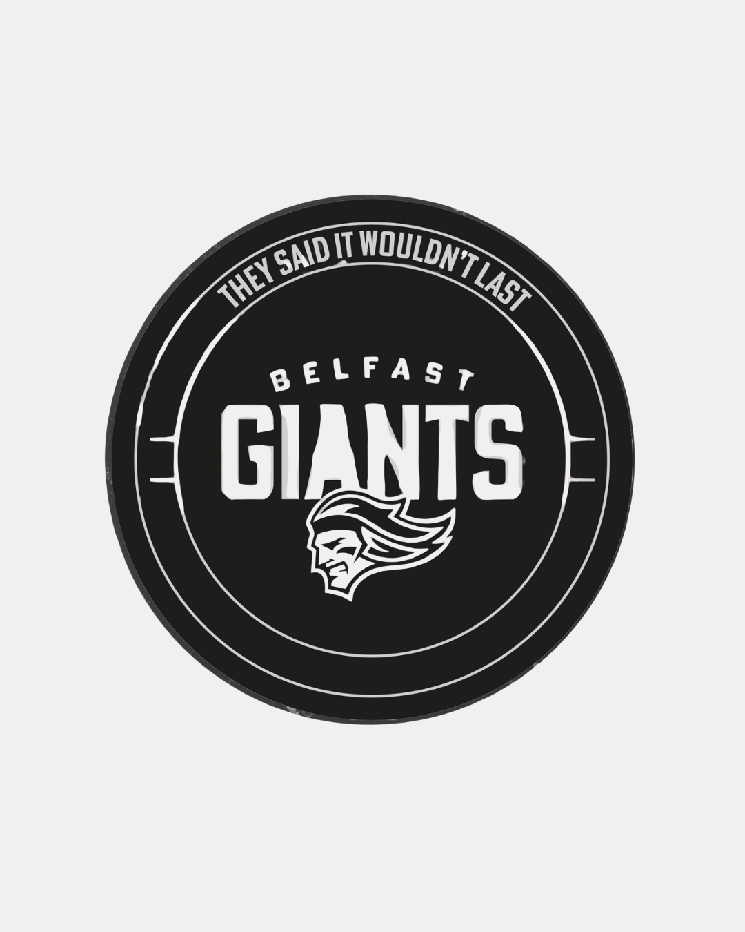 The Belfast Giants Statue Puck is a black puck featuring "THEY SAID IT WOULDN'T LAST" around the edge, bold "BELFAST GIANTS" at the center, and a stylized head logo below. Officially from the Belfast Giants brand.