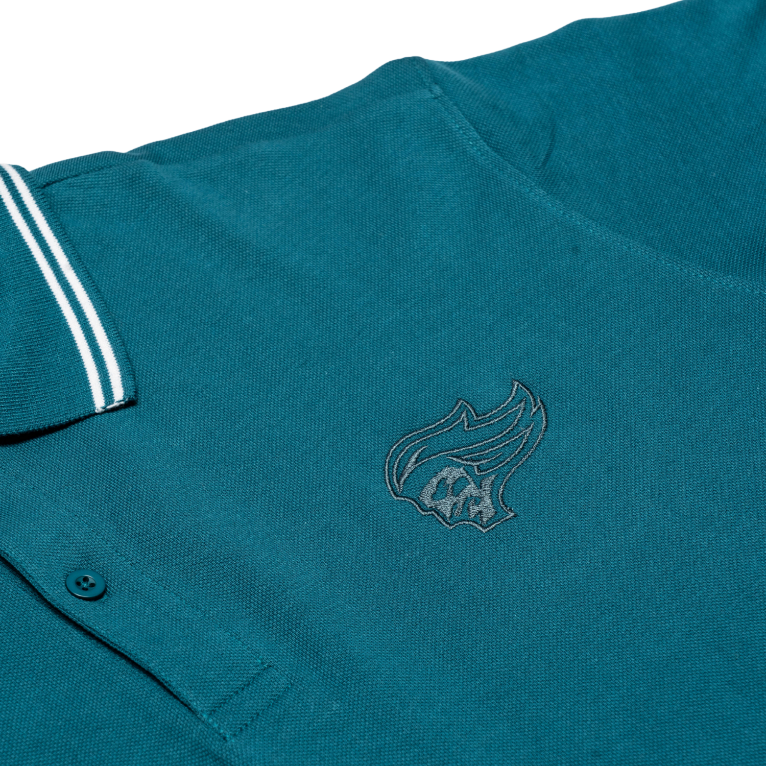 The Belfast Giants Teal Polo Shirt features a white-striped collar and an embroidered flame and skull logo—ideal as your next match-day shirt from the Belfast Giants.