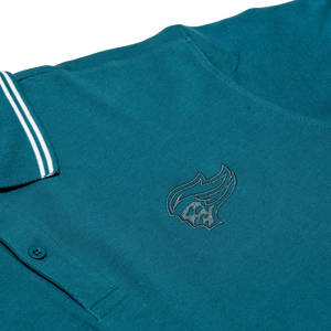 The Belfast Giants Teal Polo Shirt features a white-striped collar and an embroidered flame and skull logo—ideal as your next match-day shirt from the Belfast Giants.