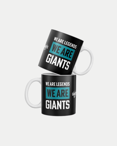 Two black ceramic "We Are Legends, We Are Giants" mugs by Belfast Giants, each with a white handle and bold teal and white text. Made-to-order to reduce waste. Shown stacked against a plain white background.