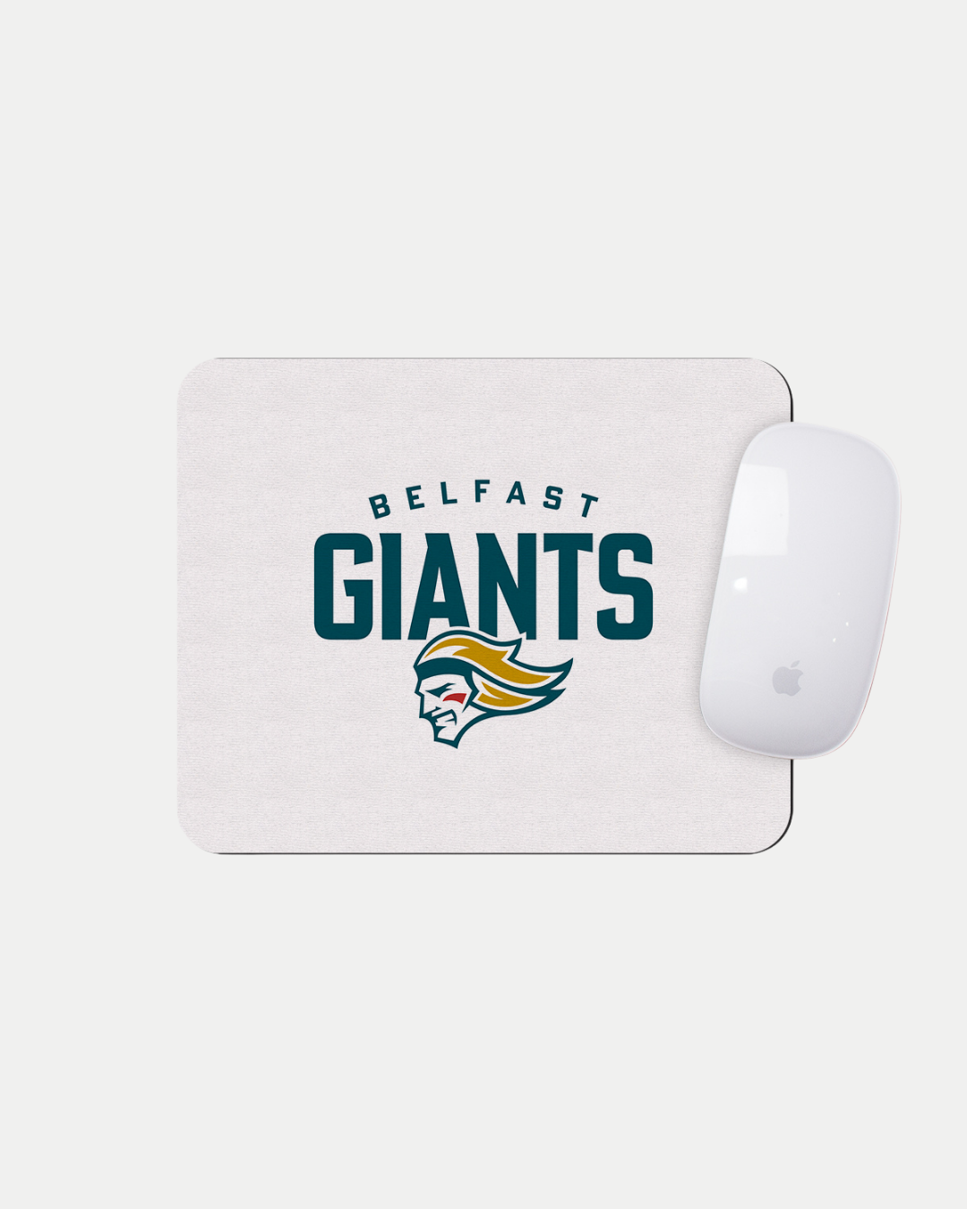 The Belfast Giants Logo White Mousemat by Belfast Giants features a fierce green, gold, and white giant head logo on a made-to-order white mat—custom crafted to reduce waste. An Apple Magic Mouse rests in the top-right corner.
