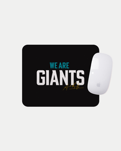 The We Are Giants Black Mousemat by Belfast Giants features bold white and blue "WE ARE GIANTS" text with a gold signature below. Made to order, it displays an Apple Magic Mouse on the top right corner of the mat.
