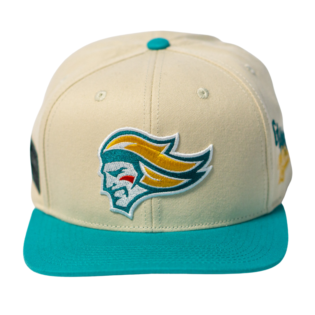 The Belfast Giants Hockey Cap Off-White by Belfast Giants is an off-white adjustable hat with a teal brim and features a yellow and teal embroidered stylized knight’s head logo on the front.