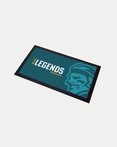 The We Are Legends Bar Runner by Belfast Giants is a rectangular, custom mat with a teal background, bold white and yellow “PLACE FOR LEGENDS” text, and a stylized profile of a face on the right side.