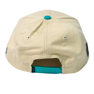 The Belfast Giants Hockey Cap Off-White features a teal adjustable snapback closure and a matching teal top button, shown from the back.