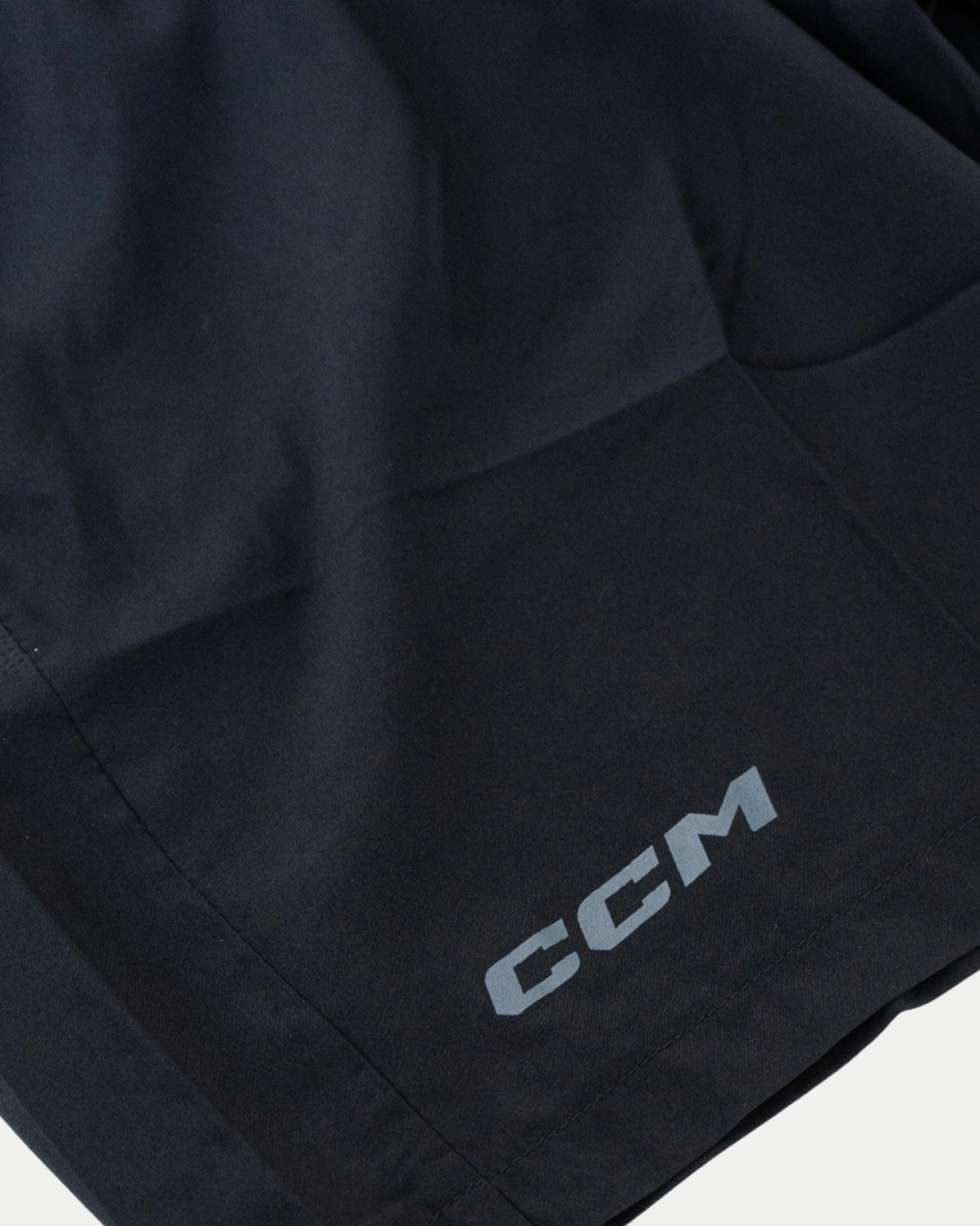 Close-up of Belfast Giants CCM Training Shorts in black, featuring the white CCM logo printed near the hem.