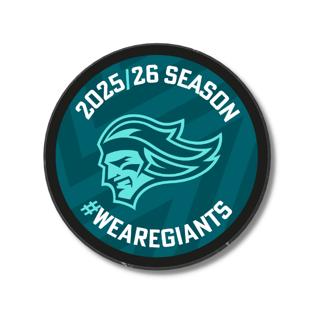 The Logo Season Puck Teal 25-26 from Belfast Giants Store by National Merchandise features a round teal badge with a stylized giant’s head, “2025/26 Season” above, “#WEAREGIANTS” below, and a subtle zigzag background.