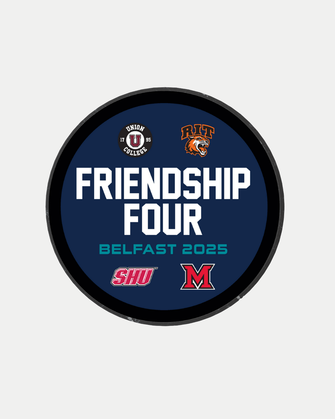 The CLICK & COLLECT Friendship Four 2025 Team Logos Puck from Belfast Giants Store features Union College, RIT, Sacred Heart, and Miami University logos with bold FRIENDSHIP FOUR and BELFAST 2025 text, celebrating SSE Arena Belfast’s thrilling event.