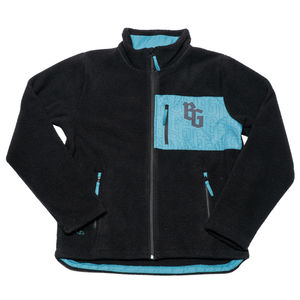 The Belfast Giants Pile Jacket BG Logo is a black fleece-lined jacket with a high collar, light blue zipper accents, and a zippered chest pocket featuring a geometric pattern and bold BG monogram, finished with a stylish textured edge.