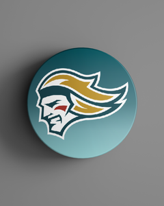 The Belfast Giants Colour Logo Puck 25-26 from Belfast Giants Store by National Merchandise features a stylized warrior’s head in profile with flowing yellow hair, a white face, and red mark on the cheek against a teal background.