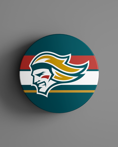 The Belfast Giants Striped Hockey Puck 25-26 from the Belfast Giants Store by National Merchandise features a round badge with a stylized knight's head in teal, gold, and white over red, white, teal, and gold stripes on a gray background.