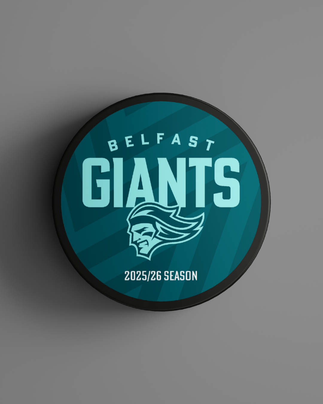 The Logo Season Puck Text 25-26 from Belfast Giants Store by National Merchandise features the Belfast Giants logo, "Belfast Giants" text, and "2025/26 Season" on a teal background with a stylized giants head.