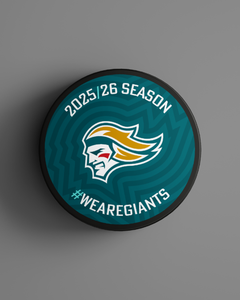 The Logo Season Puck Gold 25-26 from Belfast Giants Store by National Merchandise features a teal face, stylized giant’s head logo, “2025/26 Season” at the top, and #WEAREGIANTS at the bottom on a gray background.