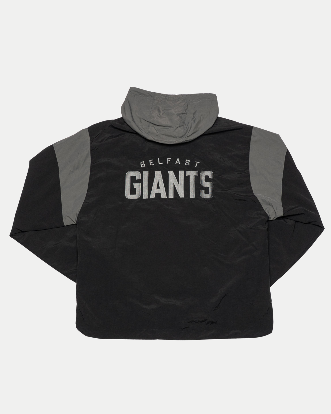 The Belfast Giants Anorak Black by Belfast Giants is a black and grey half-zip jacket featuring a bold grey Giants logo—ideal for cold weather.