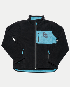 The Belfast Giants Pile Jacket BG Logo is a black fleece-lined jacket with turquoise accents, including a zippered chest pocket featuring the BG logo, side pockets, interior lining, and a subtle geometric pattern on the turquoise areas.