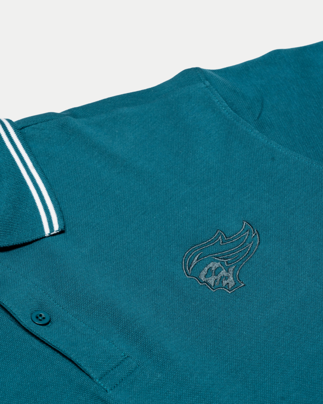 The Belfast Giants Teal Polo Shirt by Belfast Giants features white-striped collar details and an embroidered flame logo on the chest, displayed flat on a white background.