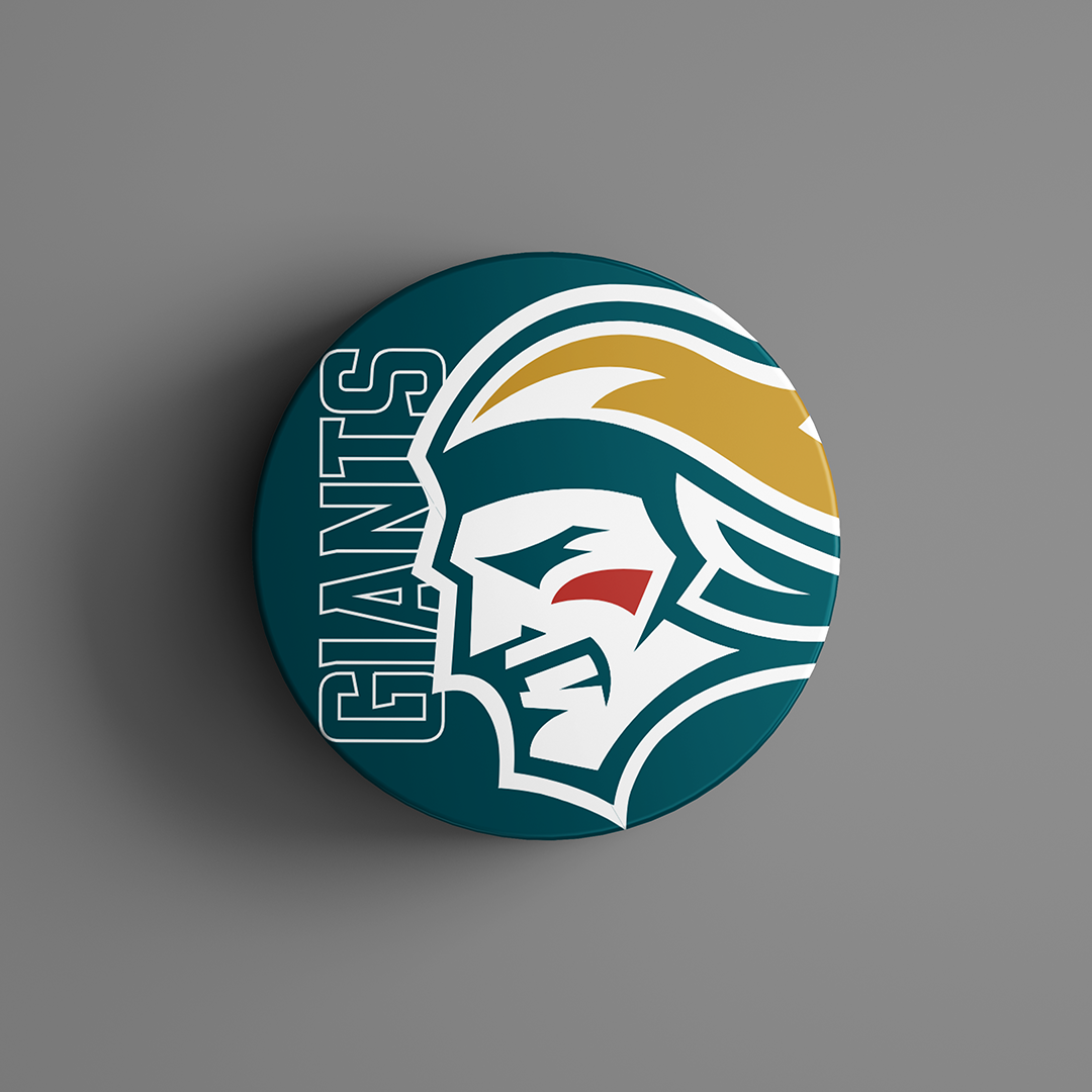 The Belfast Giants Logo Puck 25-26 features a round pin with a stylized warrior profile in white, yellow, red, and teal beside bold teal “GIANTS” lettering on a matching background. Available from Belfast Giants Store by National Merchandise.